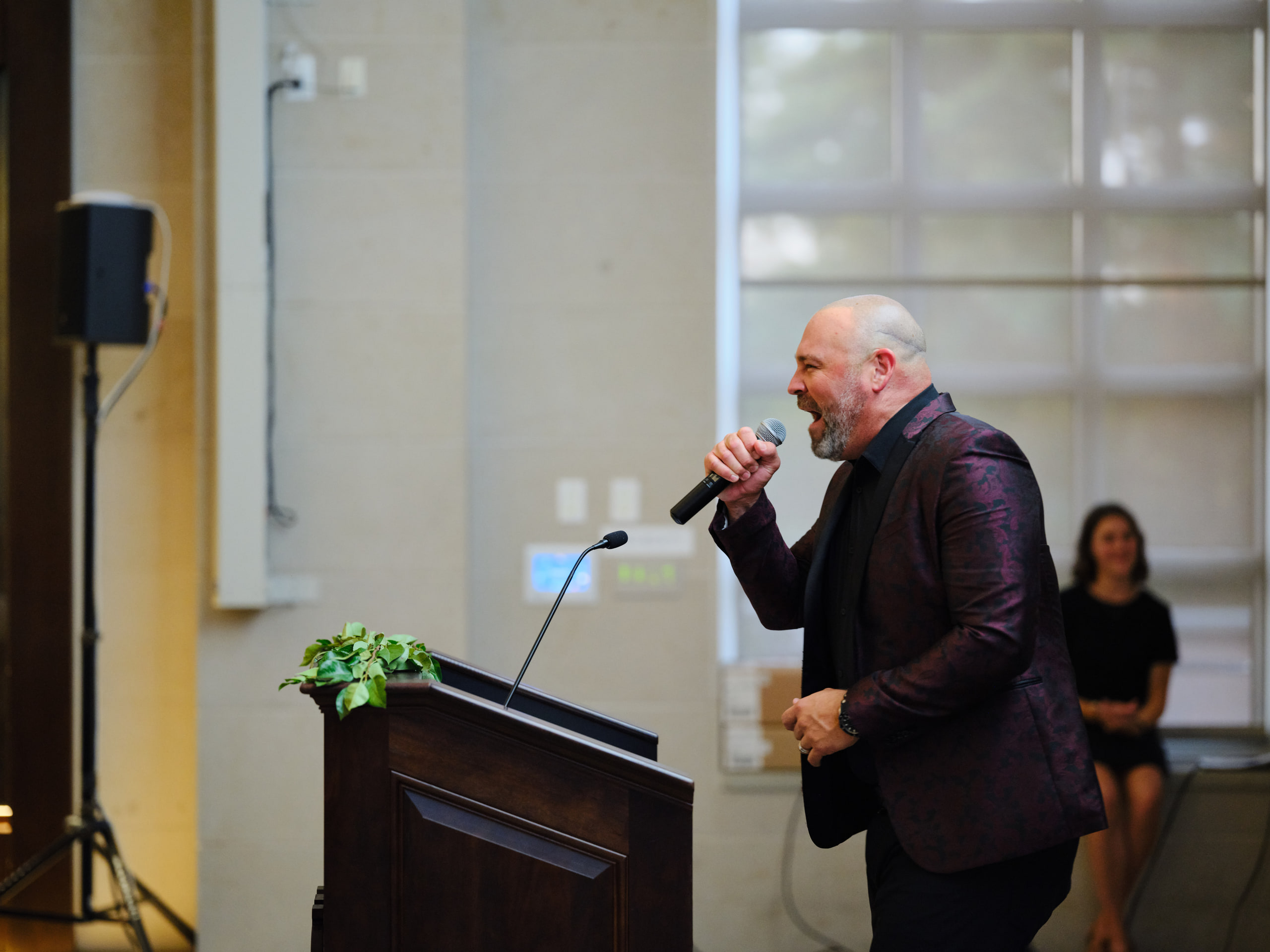 Speaker at the podium, mic, gesture.