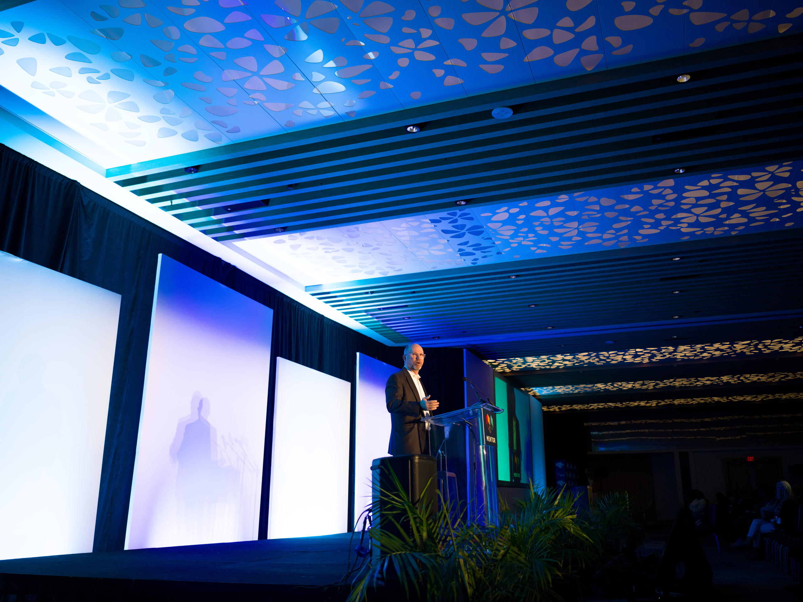 Ballroom under blue, lit ceiling grid, graphic.