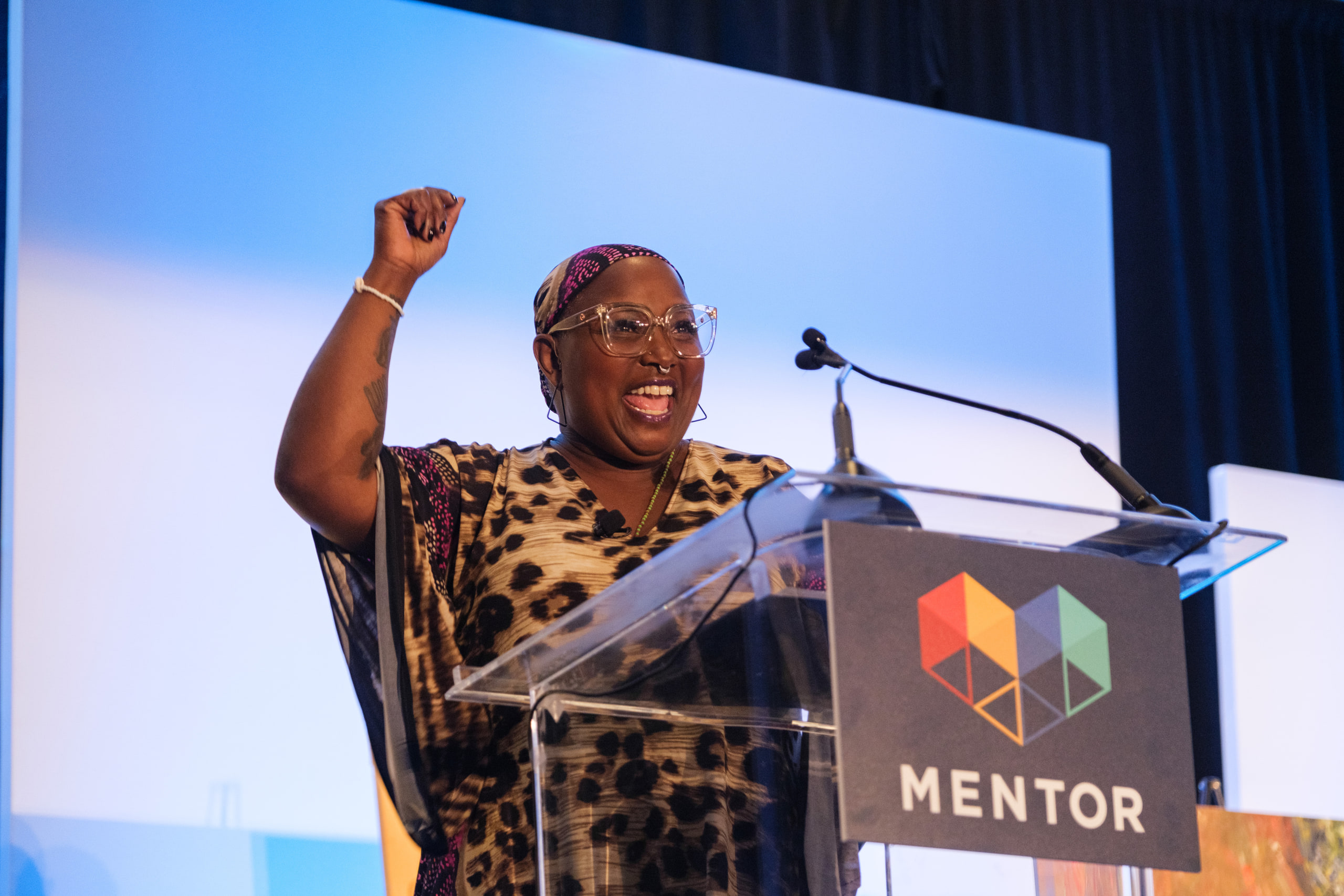 Speaker, fist up, MENTOR podium, the moment.