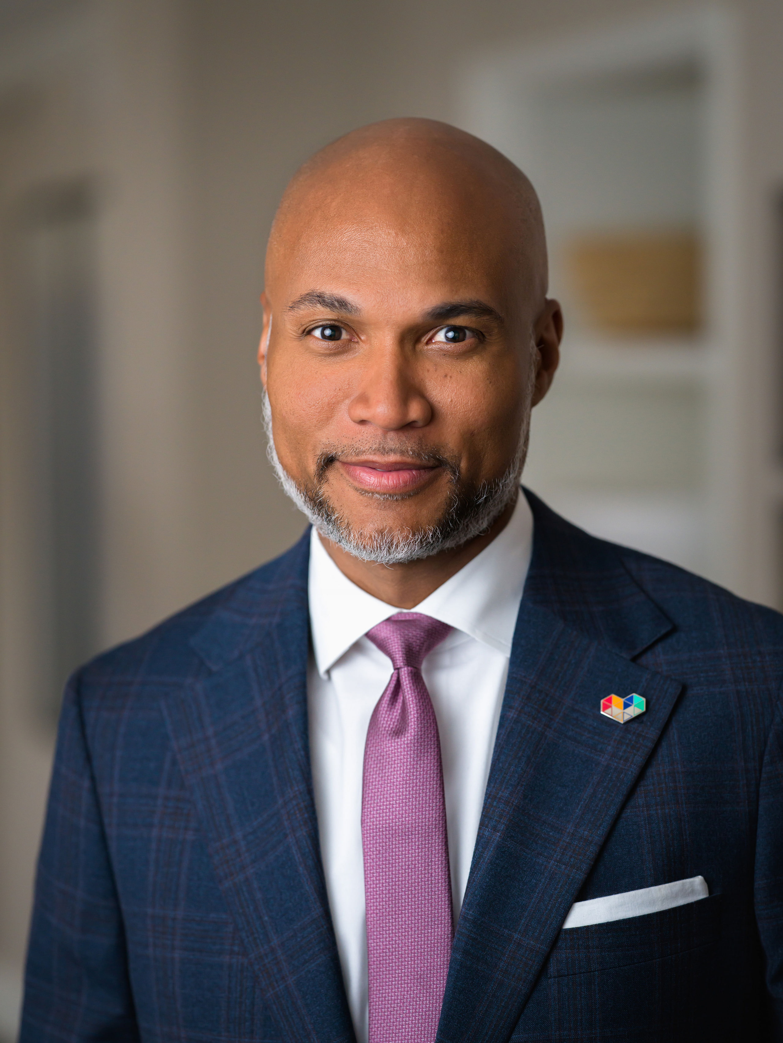 A corporate portrait from an on-site portrait day: a man in a suit and tie against a dark background