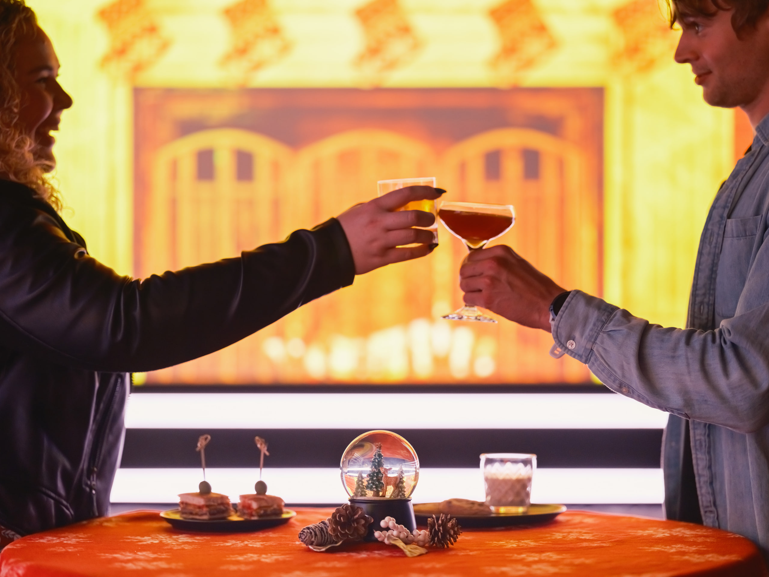 Silhouettes against a gold-lit bar, pure shape.