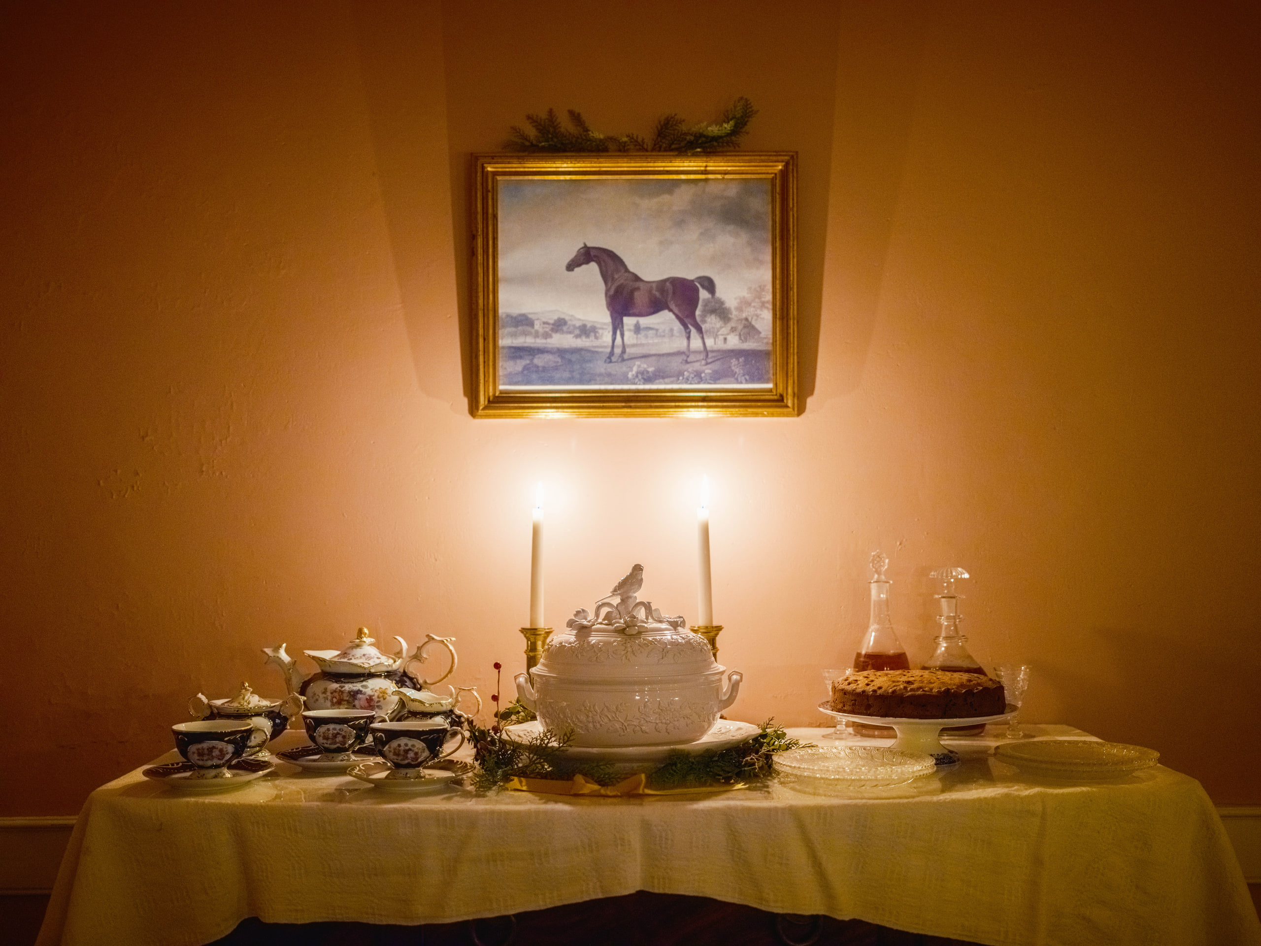 Lamp-lit room, a horse painting above.