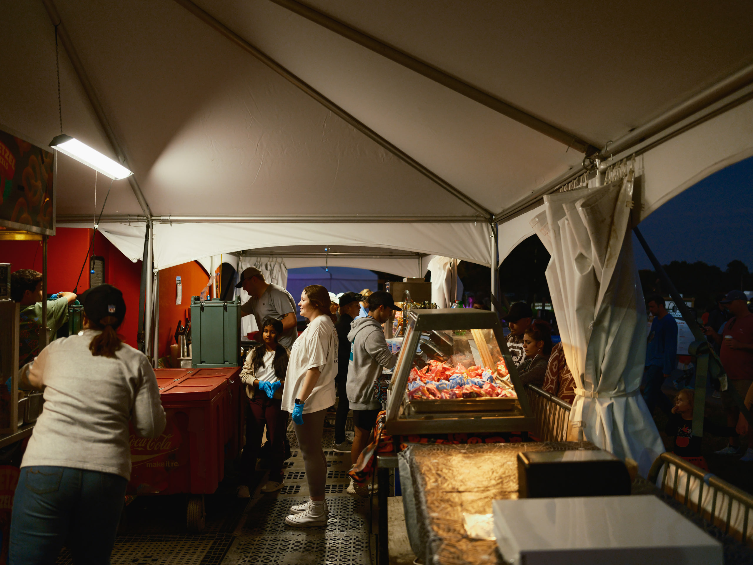 Tent at night, lit, crowd inside.