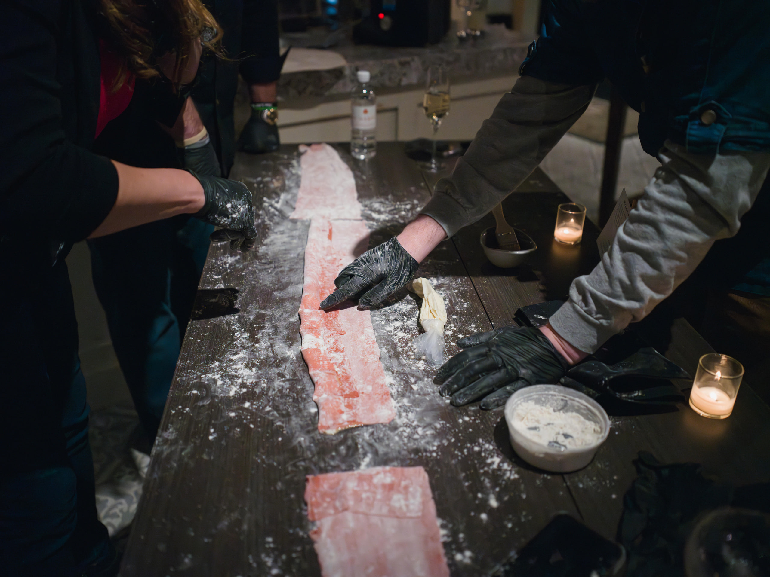 Pasta rolling, flour catching the light.